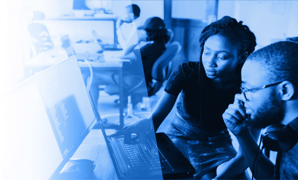 A woman assisting a man at a computer workstation
